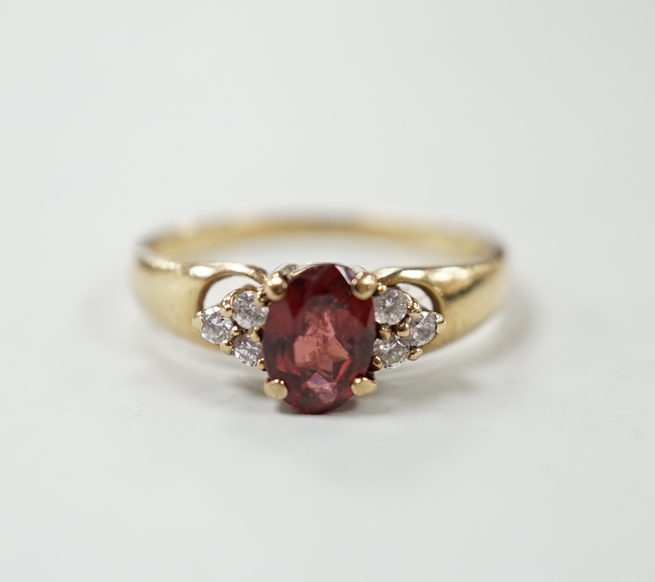 A modern 9ct gold, garnet and white sapphire? set cluster ring, size O, gross weight 2.2 grams.